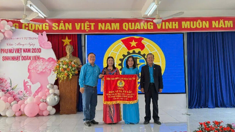 Chairman of Lam Dong Provincial Labor Federation - Mr. Hoang Lien (right) presented the Excellent Emulation Flag of the General Confederation to the Trade Union of Ly Tu Trong Primary School. Photo: X.THANH