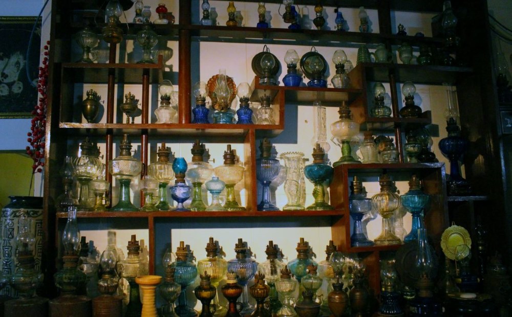 Admiring ancient southern lamps of a female collector in An Giang