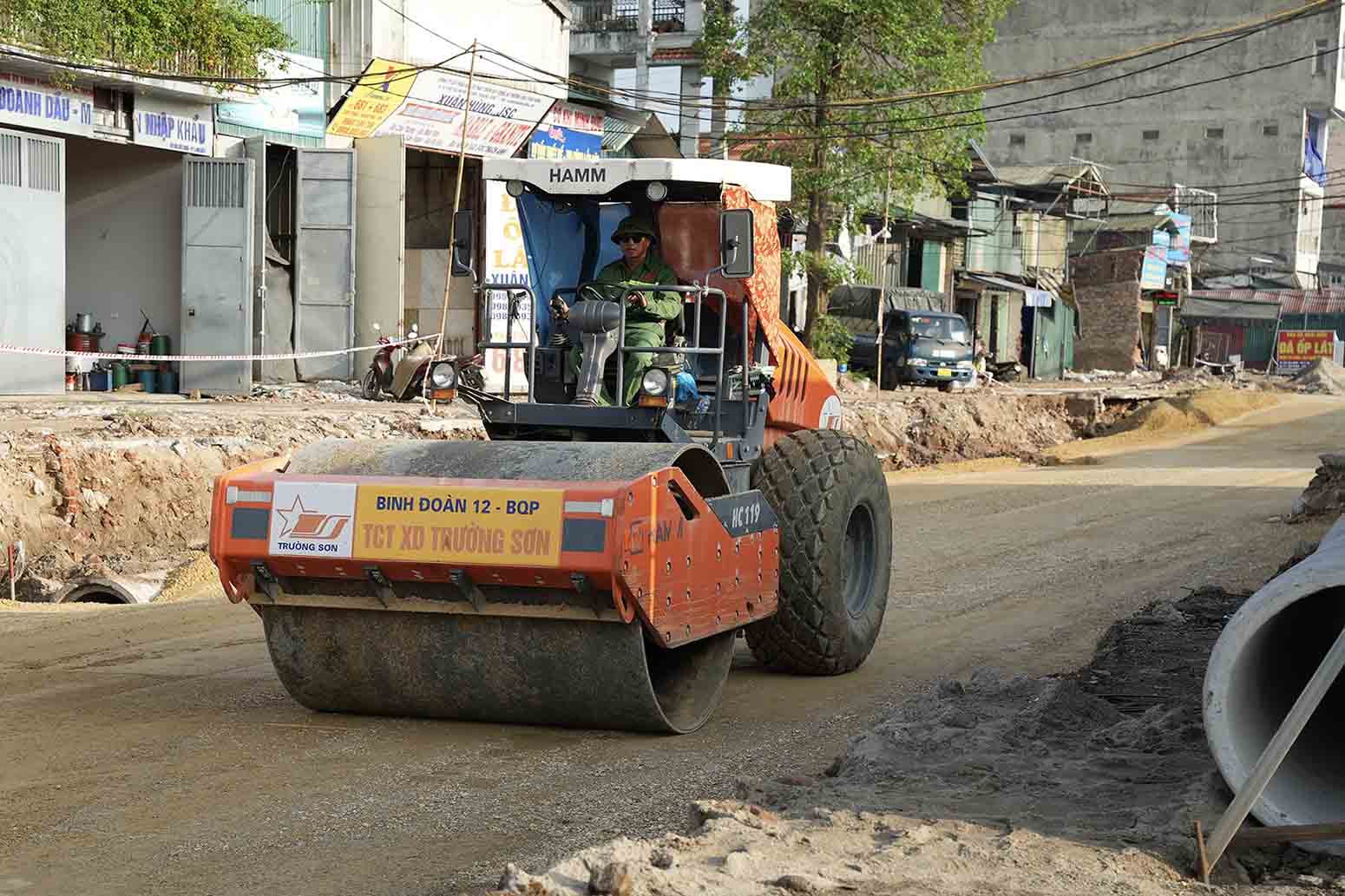 Theo ghi nhan cua PV, tren cong truong thi cong mo rong duong Tam Trinh, tranh thu thoi tiet nang rao, nha thau da huy dong hang chuc may lu, may ui, may xuc, voi khoang 50 nhan su tap trung thi cong cac hang muc nhu: ha ngam he thong cong thoat nuoc thai, thoat nuoc mua, dao dap nen duong, rai cap phoi da dam cung nhu xu ly nen dat yeu tai cac vi tri da co mat bang sach.