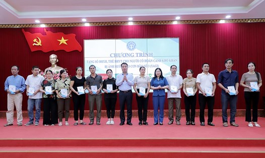 Tổng Giám đốc BHXH Việt Nam Nguyễn Thế Mạnh trao tặng sổ BHXH, thẻ BHYT cho người dân huyện Yên Bình, tỉnh Yên Bái. Ảnh: BHXH VN