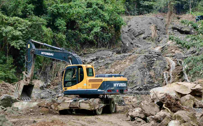 Máy móc vẫn đang thu dọn, xử lý điểm bị bùn thải tràn qua. Ảnh: Ngọc Minh