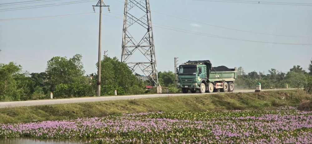 Xe chở theo asphalt đi ra từ trạm trộn không được che, phủ bạt. Ảnh: Trung Du 