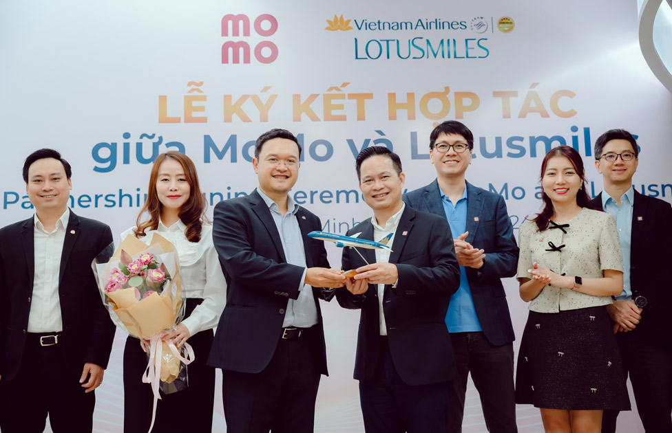 Vietnam Airlines representative presents logo to MoMo representative. Photo: Provided by DN