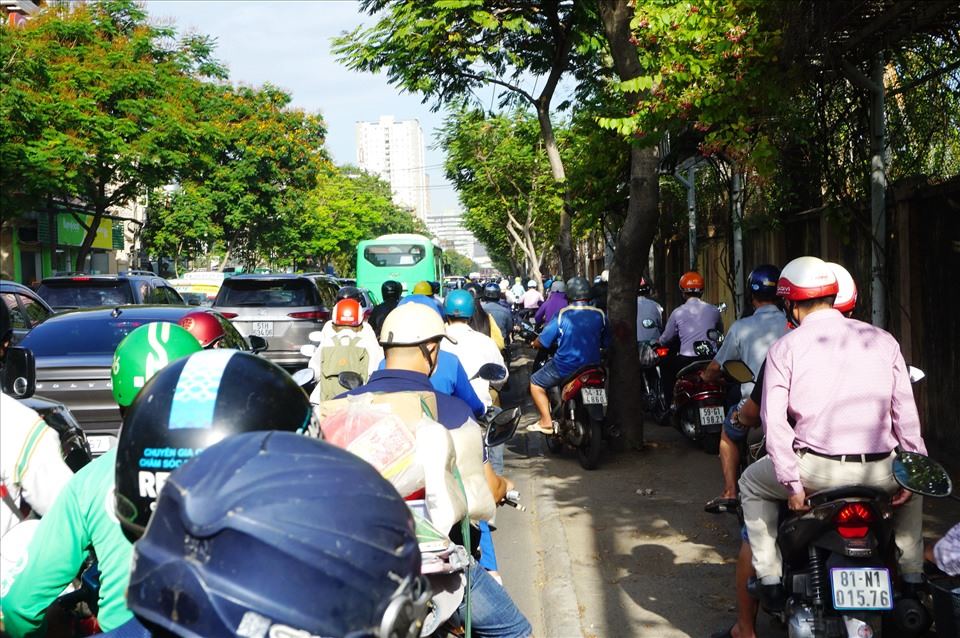 Duoi duong un u, nhieu nguoi di xe may leo len via he duong Nguyen Tat Thanh.  Anh: Minh Quan