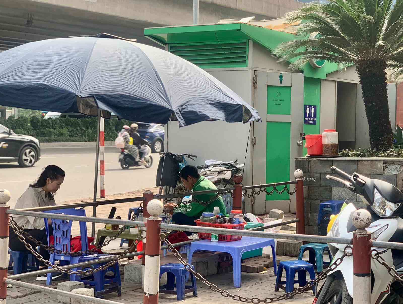 Một quán trà đá xuất hiện cạnh nhà vệ sinh công cộng trên đường Phạm Hùng (Hà Nội). Ảnh: Nhật Minh