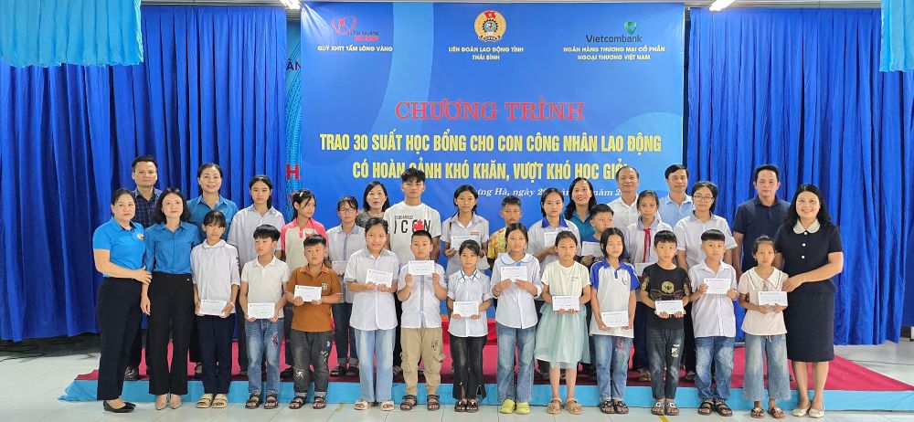 The organizing committee awarded scholarships from the Golden Heart Social Security Fund and took souvenir photos with 30 children of workers of Hung Ha Garment Company Limited who are in difficult circumstances. Photo: Trung Du