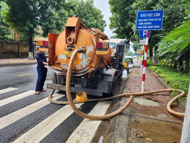 Cong nhan moi truong lien tuc hut tap chat ben trong cac cong thoat nuoc xung quanh Benh vien Da khoa tinh Quang Ngai, nham khoi thong dong chay moi khi co mua lon. Anh: Vien Nguyen