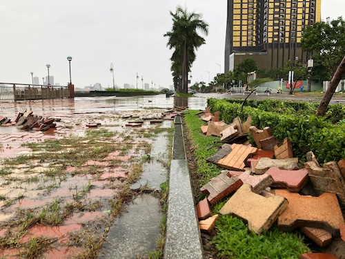 The sidewalk along the Da Nang river was hit by waves, causing bricks to be ripped off and street lights to fall. Photo: Nguyen Linh