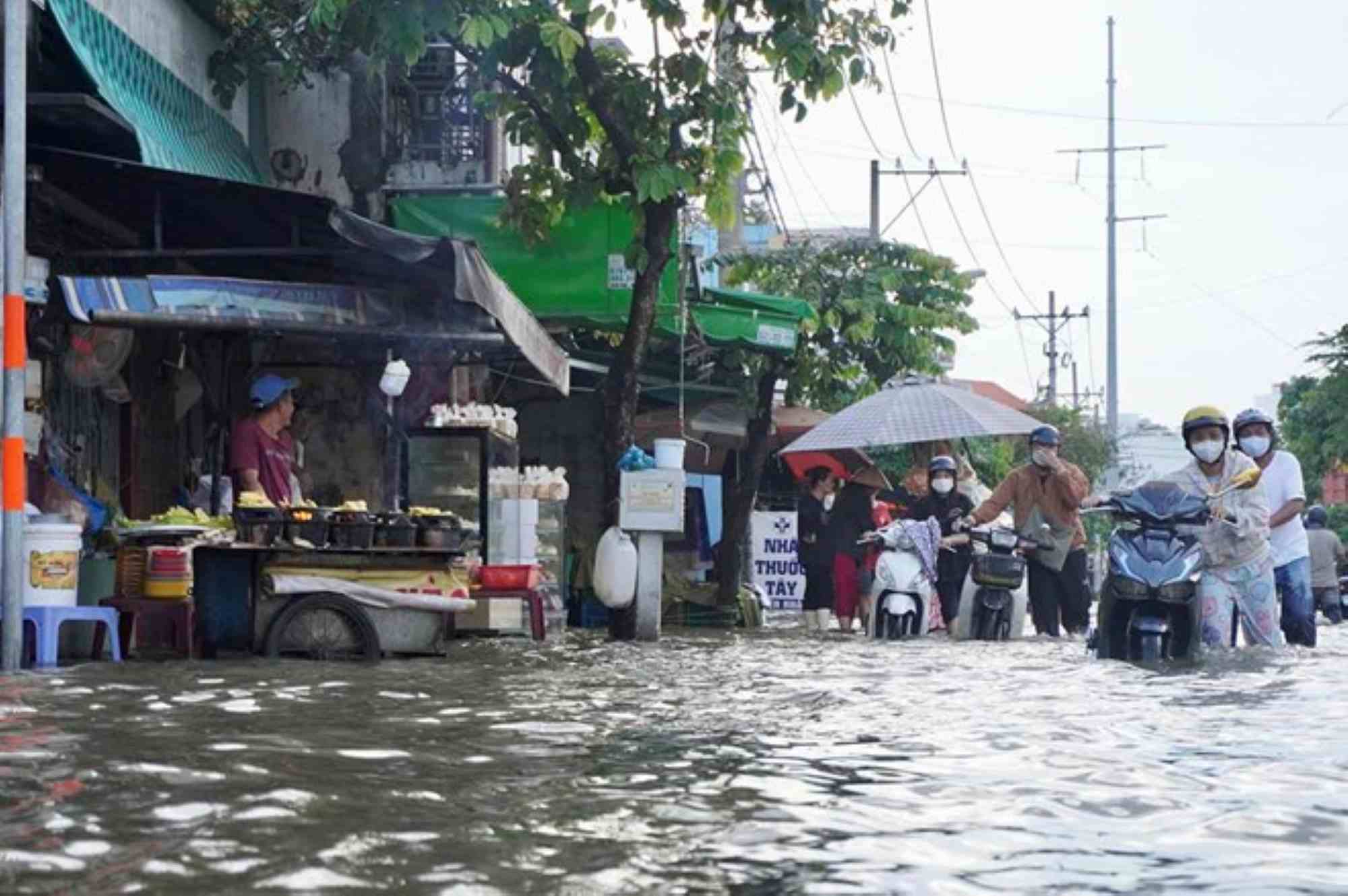 Ho Chi Minh City residents struggle because of high tides causing flooding on Tran Xuan Soan Street (District 7). Photo: Nhu Quynh