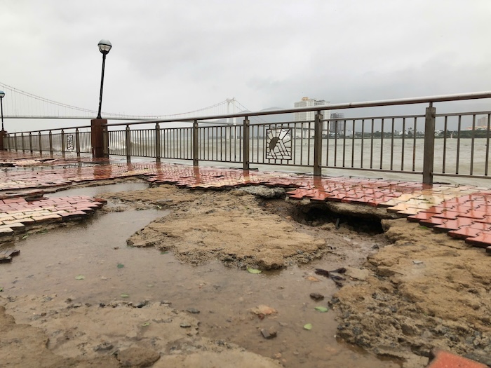 The sidewalk along the Da Nang river was hit by waves, causing bricks to be ripped off and street lights to fall. Photo: Nguyen Linh