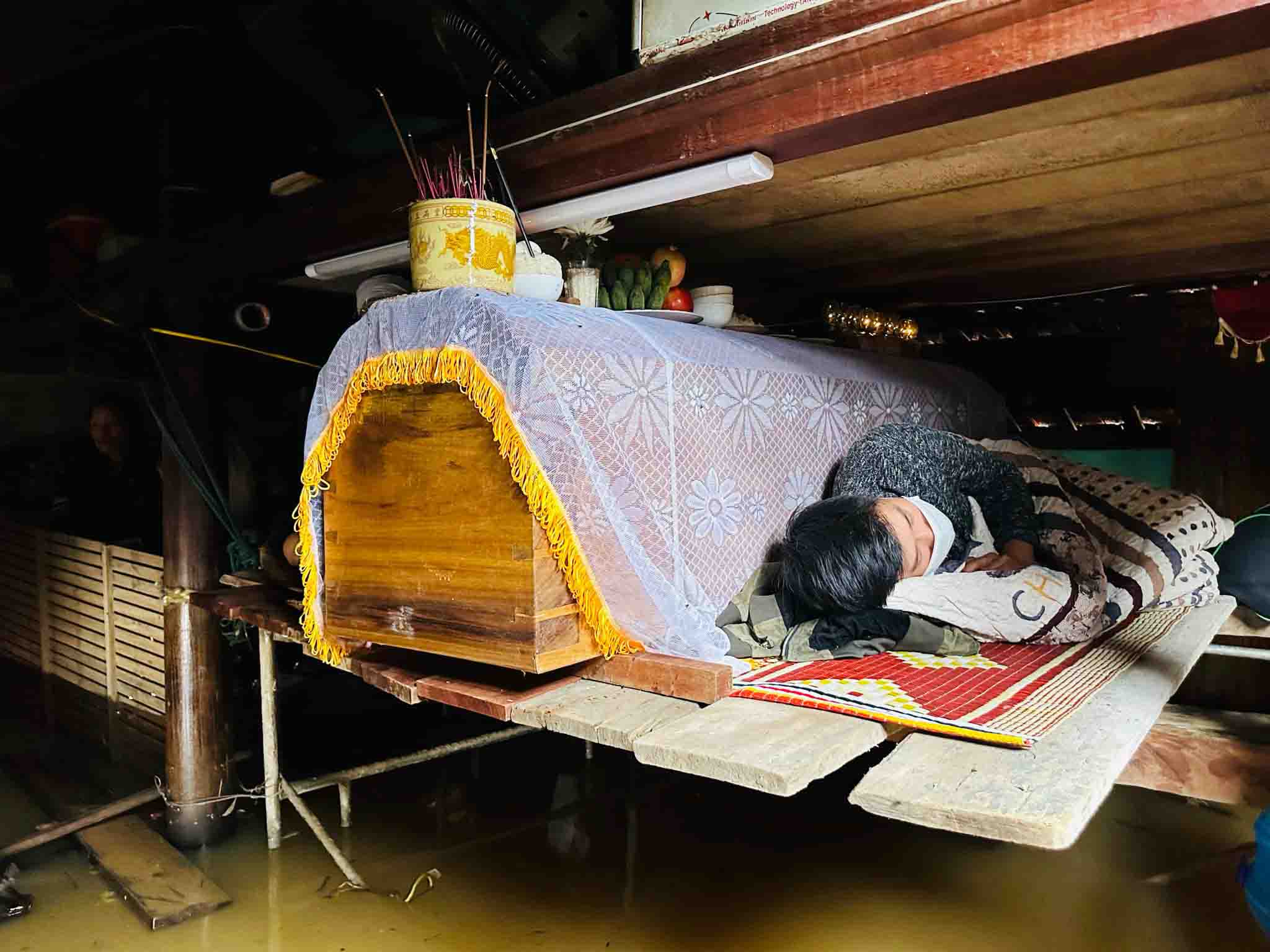 The coffin was placed near the roof, waiting for the water to recede for burial. Photo: Dung Quan