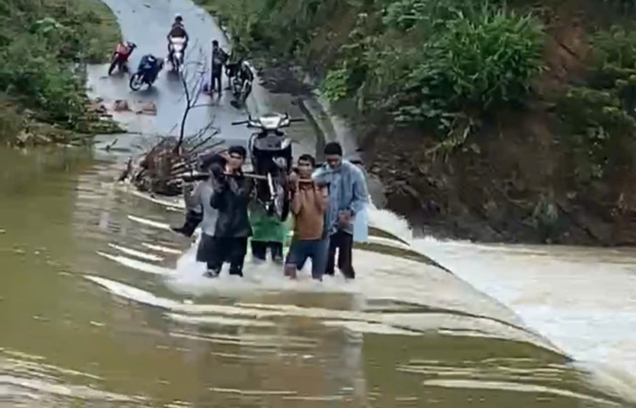 Young men in Cat and Tria villages carry their vehicles through flooded tunnels. Photo: Provided by local people.