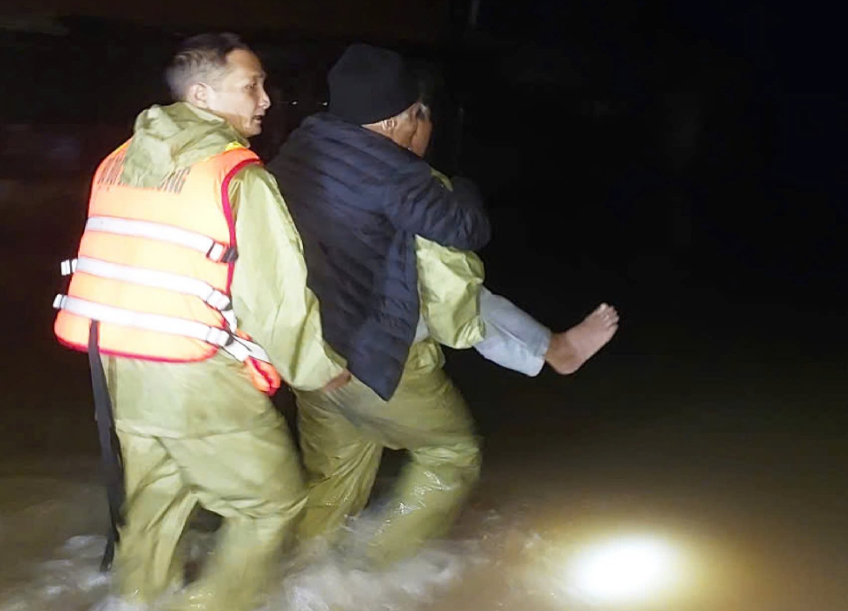 Quang Binh Border Guards took turns carrying a patient 2km across floodwaters to the emergency room at night. Photo: Border Guards