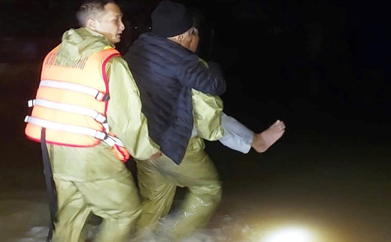 Quang Binh Border Guards took turns carrying a patient 2km across floodwaters to the emergency room at night. Photo: Border Guards