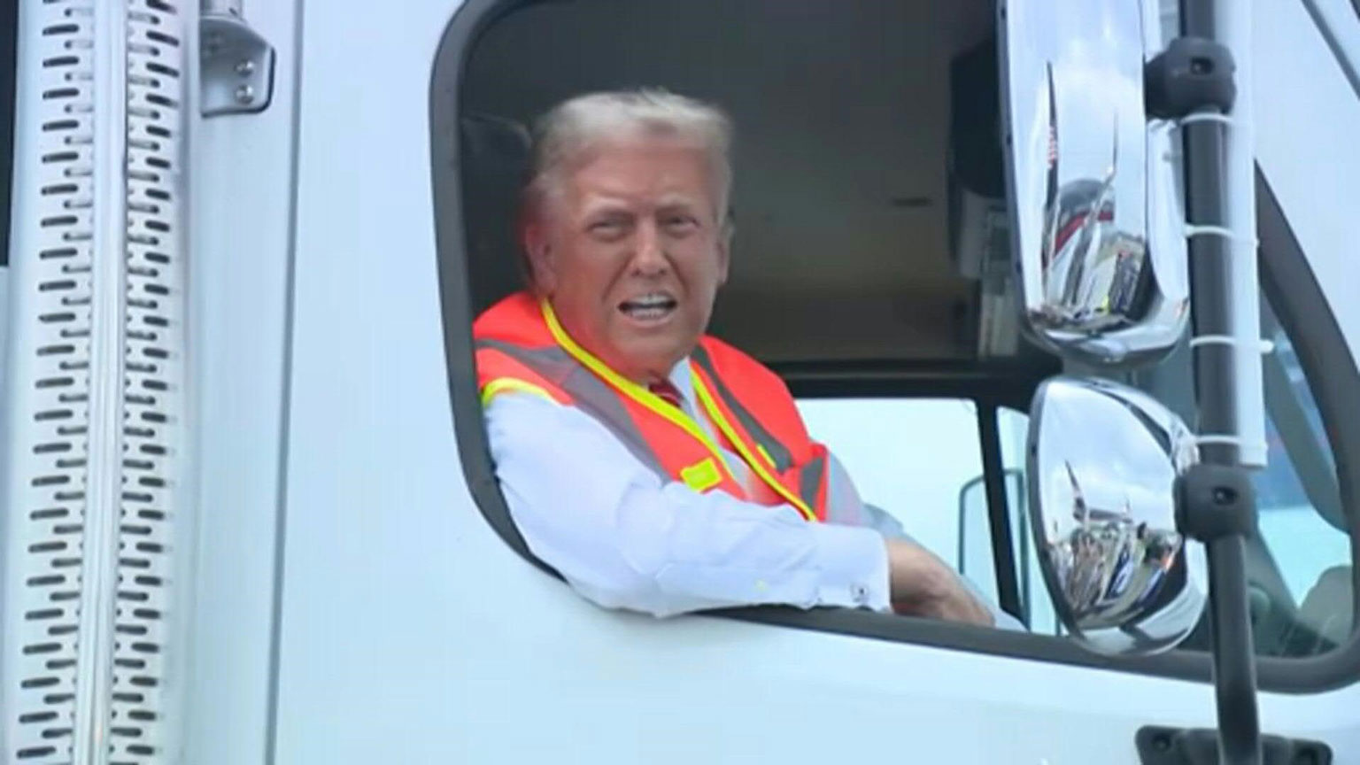 Mr. Trump is sitting in the passenger seat of a garbage truck. Photo: AFP