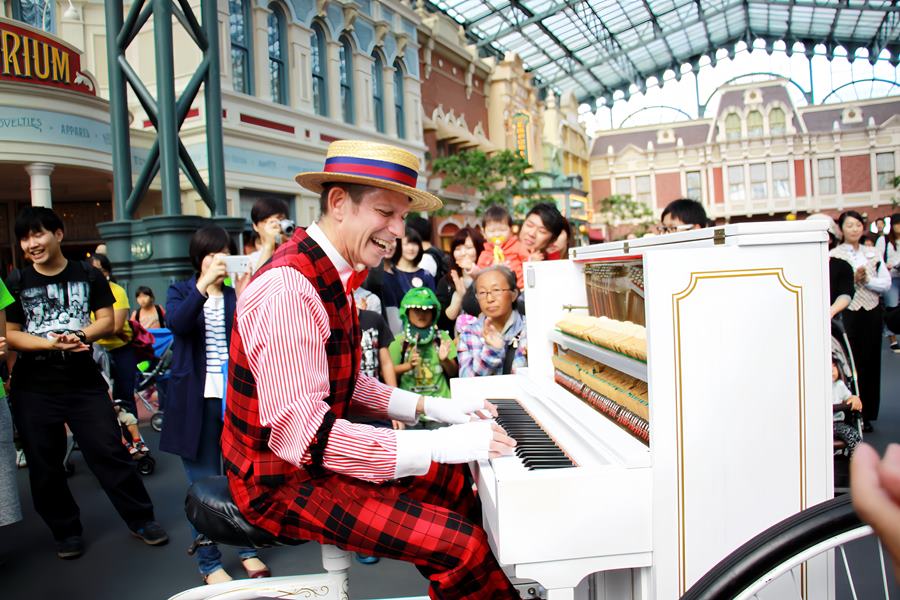 Mot nghe si voi nu cuoi rang ro ben cay dan piano, danh tang nhung giai dieu ron rang cho khan gia trong khuon vien cua Tokyo Disneyland.