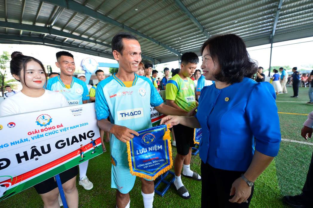 Bà Thái Thu Xương - Phó Chủ tịch Thường trực Tổng liên đoàn Lao động Việt Nam tặng cờ lưu niệm cho các đội tham gia giải đấu. Ảnh: Quang Định