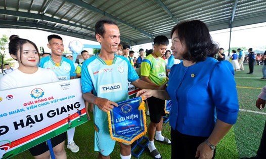 Bà Thái Thu Xương - Phó Chủ tịch Thường trực Tổng liên đoàn Lao động Việt Nam tặng cờ lưu niệm cho các đội tham gia giải đấu. Ảnh: Quang Định