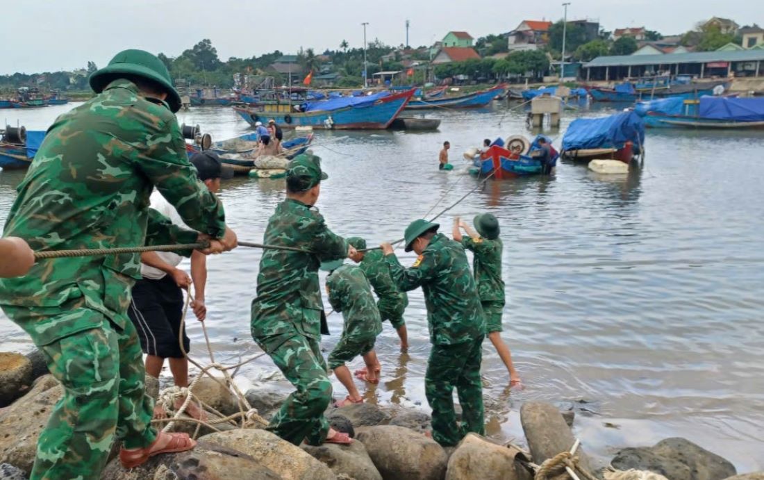 Forces pull the sunken fishing boat ashore for repairs. Photo: Cua Tung Border Guard.