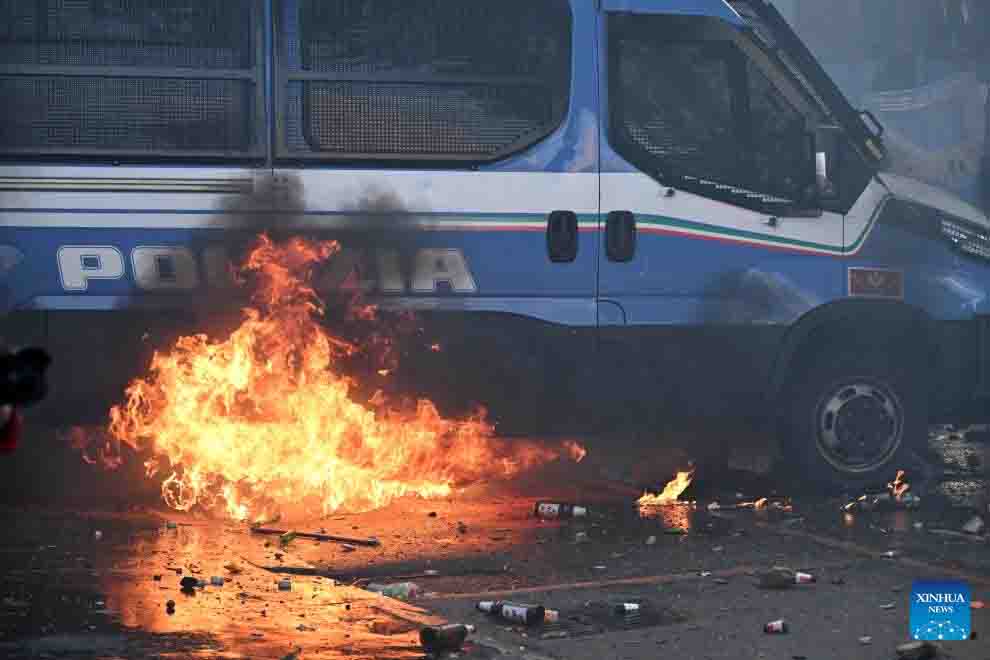 Xe cảnh sát ở Italy bốc cháy do bom tự chế của người biểu tình chống chiến tranh Trung Đông ngày 6.10. Ảnh: Xinhua