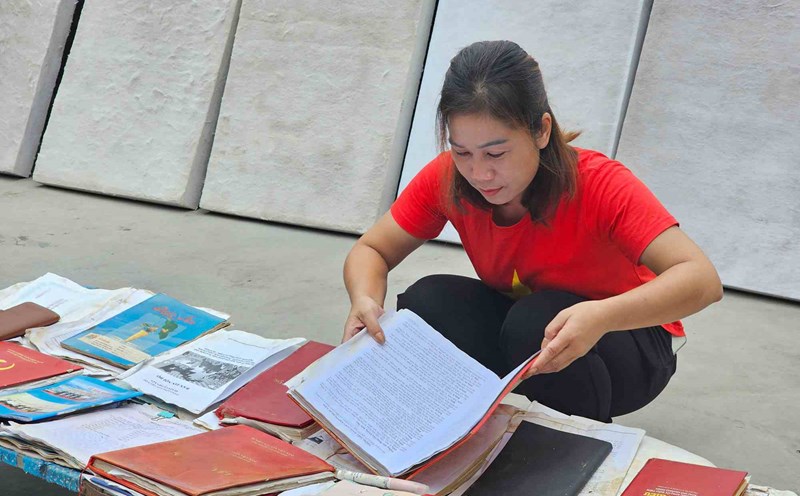 Ms. Nong Thi Tram, Head of Ha Trang Tay Village, Dong Hai Commune, is drying documents and books that were flooded after the storm. Photo: Doan Hung