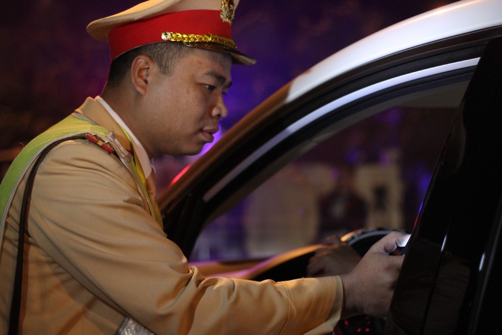 Cảnh sát giao thông kiểm tra nồng độ cồn với các tài xế lái xe. Ảnh: Trần Vương