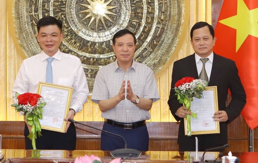 Mr. Lai The Nguyen - Standing Deputy Secretary of Thanh Hoa Provincial Party Committee - presented the decision to Mr. Dang Van Hiep (left) and Mr. Do Thanh Nam. Photo: Minh Hieu