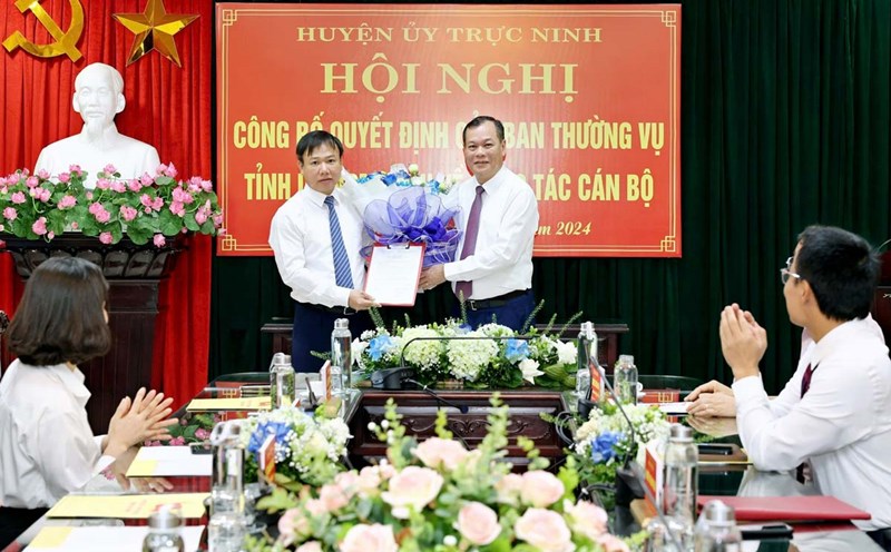 Standing Deputy Secretary of Nam Dinh Provincial Party Committee Le Quoc Chinh presented the Decision and flowers to congratulate the new Deputy Secretary of Truc Ninh District Party Committee. Photo: Vu Xuan