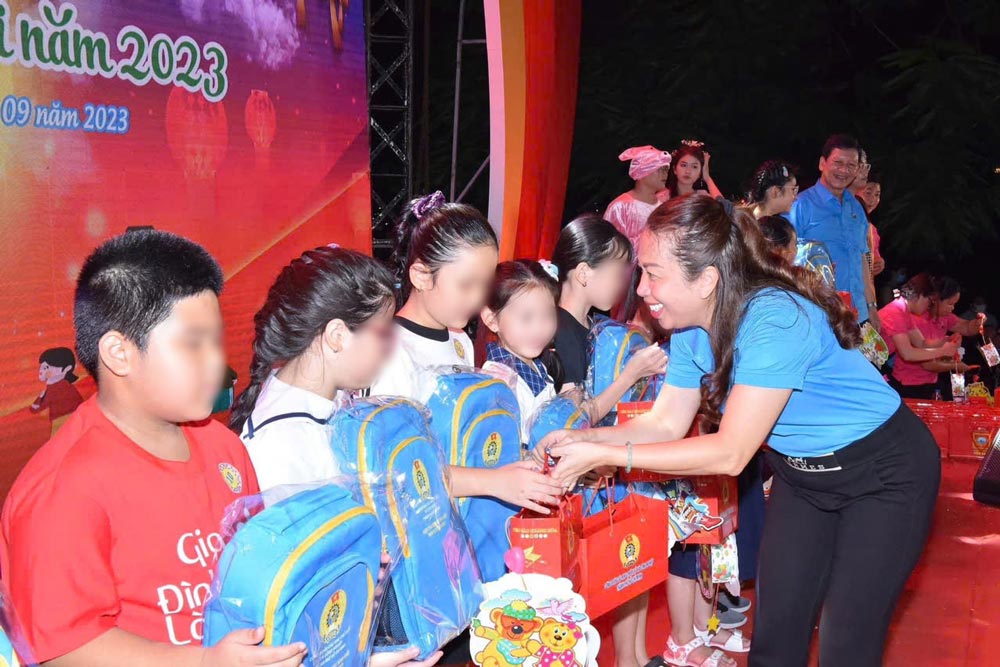 Bà Vũ Thế Vân - Chủ tịch Công đoàn các Khu chế xuất và Khu công nghiệp TPHCM tặng quà chăm lo cho con công nhân lao động. Ảnh: Đức Long