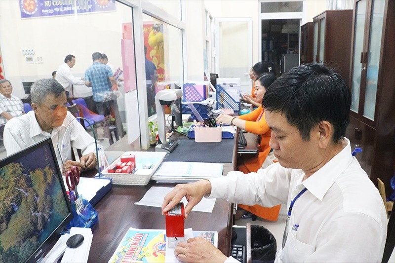 Công chức bộ phận một cửa UBND phường An Cư, quận Ninh Kiều (TP Cần Thơ) đang giải quyết hồ sơ của người dân. Ảnh: Quang Thái 