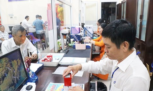 Công chức bộ phận một cửa UBND phường An Cư, quận Ninh Kiều (TP Cần Thơ) đang giải quyết hồ sơ của người dân. Ảnh: Quang Thái
