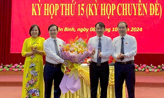Lãnh đạo huyện Yên Bình tặng hoa chúc mừng tân Chủ tịch HĐND Nguyễn Lê Dũng (thứ 2 bên trái). Ảnh: Cổng TTĐT Yên Bái