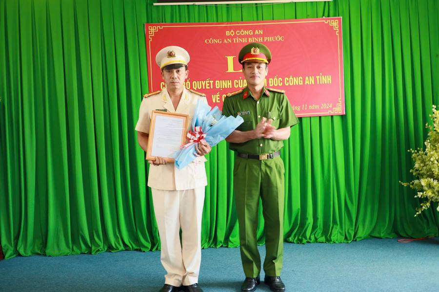 Colonel Nguyen Huy Hai - Deputy Director of Binh Phuoc Provincial Police - presented the transfer and appointment decision to Lieutenant Colonel Nguyen Hong Hai (left). Photo: Binh Phuoc Provincial Police