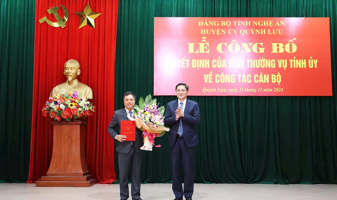 Standing Deputy Secretary of Nghe An Provincial Party Committee Hoang Nghia Hieu presented the decision and flowers to congratulate the new Secretary of Quynh Luu District Party Committee Hoang Van Bo. Photo: Hong Dien