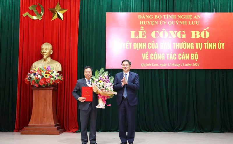 Standing Deputy Secretary of Nghe An Provincial Party Committee Hoang Nghia Hieu presented the decision and flowers to congratulate the new Secretary of Quynh Luu District Party Committee Hoang Van Bo. Photo: Hong Dien