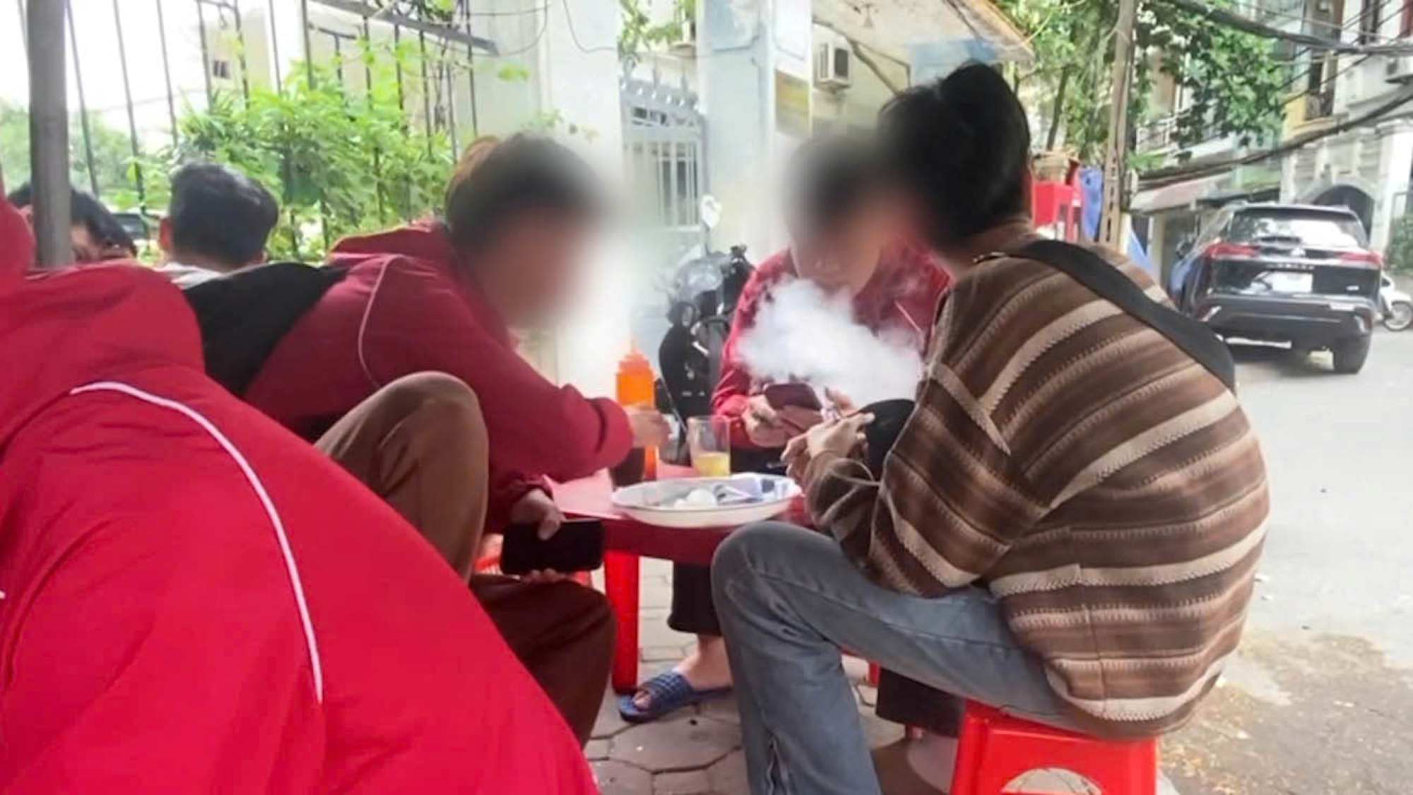 Students openly use electronic cigarettes at the school gate. Photo: Hanh Thom