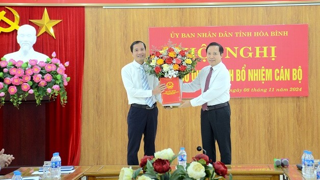 Permanent Vice Chairman of Hoa Binh Provincial People's Committee Nguyen Van Toan presented the decision and flowers to congratulate the new Deputy Director of the Department of Labor, Invalids and Social Affairs (left). Photo: Le Thuy