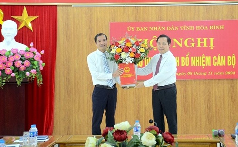 Permanent Vice Chairman of Hoa Binh Provincial People's Committee Nguyen Van Toan presented the decision and flowers to congratulate the new Deputy Director of the Department of Labor, Invalids and Social Affairs (left). Photo: Le Thuy