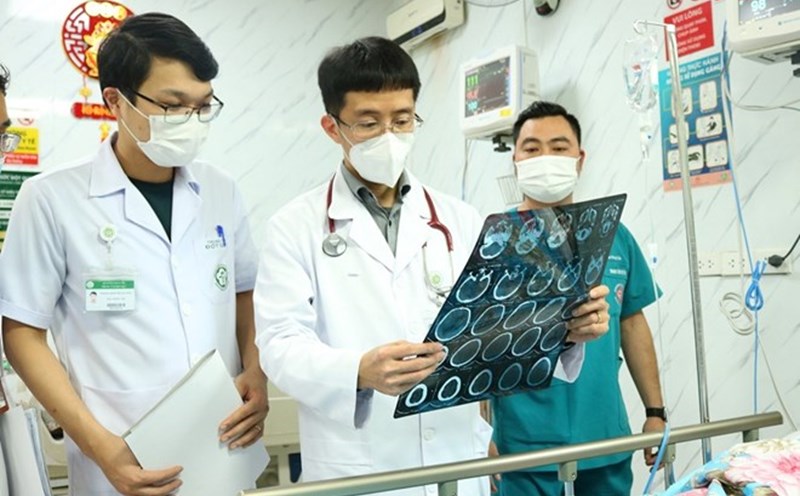 Associate Professor, Dr. Mai Duy Ton (standing in the middle) examines a patient being treated at the Stroke Center - Bach Mai Hospital. Photo: BVCC