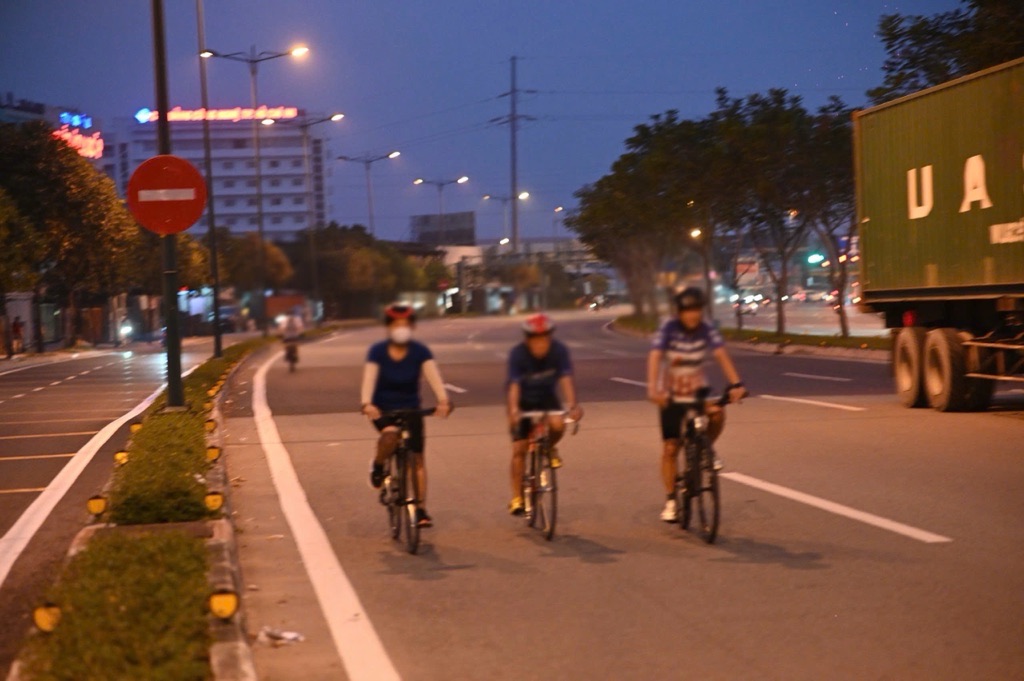 Nhieu nguoi di xe dap van luu thong trong lan o to tren dai lo Pham Van Dong bat chap nguy hiem. Anh: Dong Hoang.