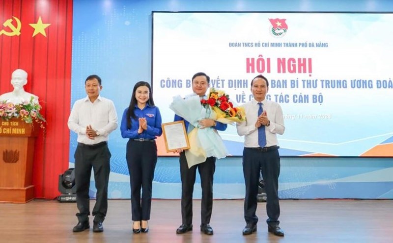 Mr. Nguyen Dinh Vinh - Standing Deputy Secretary of the Da Nang City Party Committee (right) and Mr. Doan Duy Tan - Head of the Organizing Committee of the Da Nang City Party Committee (left) presented the Decision and flowers to the new Secretary of the Da Nang City Youth Union. Photo: Ha Phan