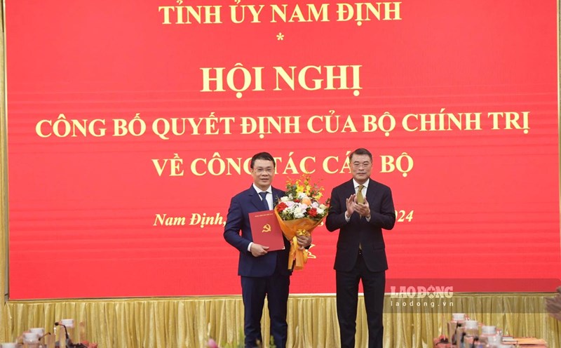 Head of the Central Organizing Committee Le Minh Hung presents the decision to the new Secretary of the Nam Dinh Provincial Party Committee. Photo: Ha Vi