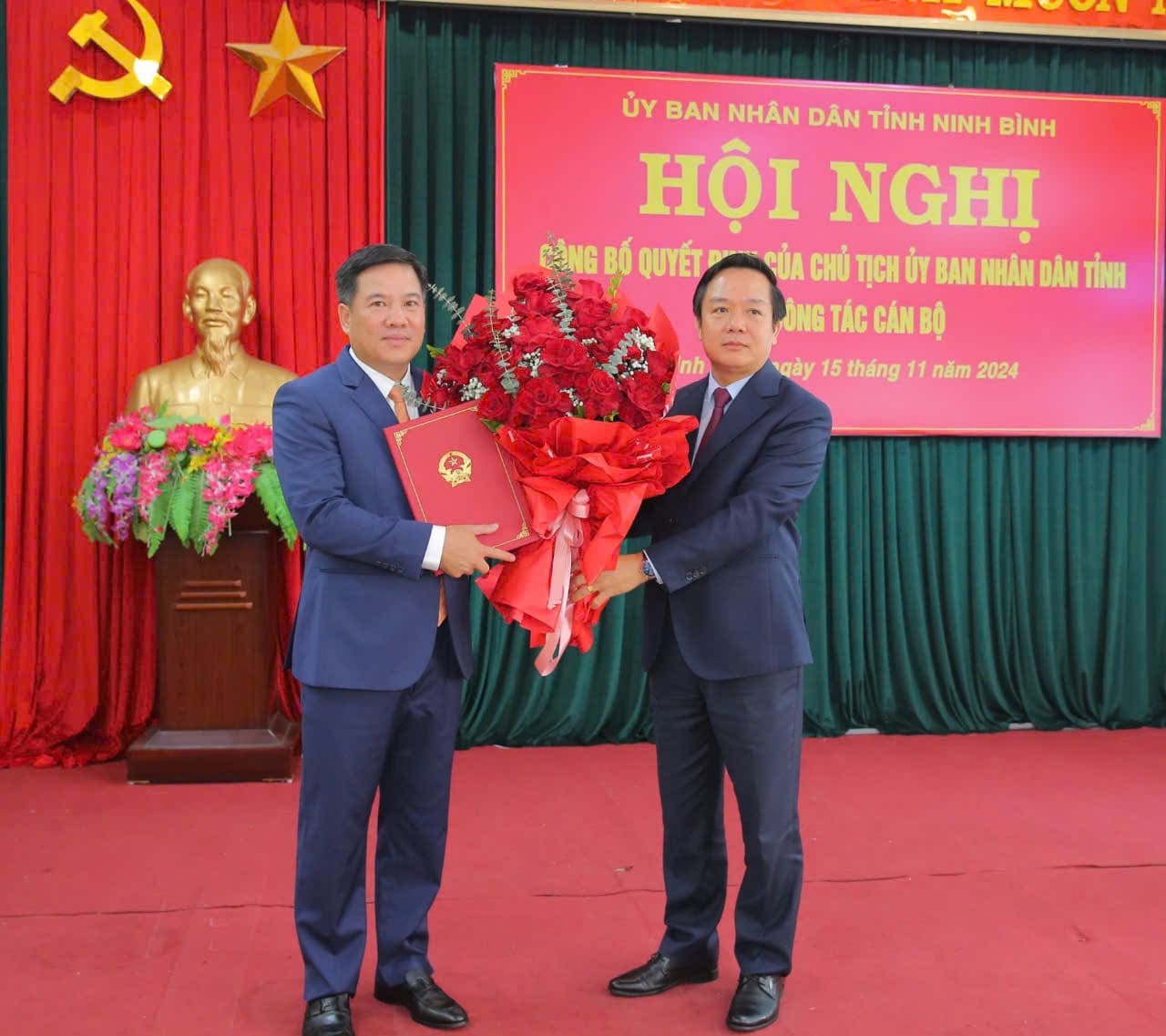 Ong Pham Quang Ngoc - Chu tich UBND tinh Ninh Binh (ben phai) trao Quyet dinh va tang hoa chuc mung ong Bui Xuan Dieu - tan Giam doc So Xay dung tinh Ninh Binh. Anh: Nguyen Truong