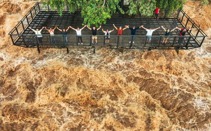 Tourists look at the Li Phi waterfall pouring into the Mekong River. Li Phi waterfall means “ghost trap” in Lao. Photo: Ngo Tran Hai An