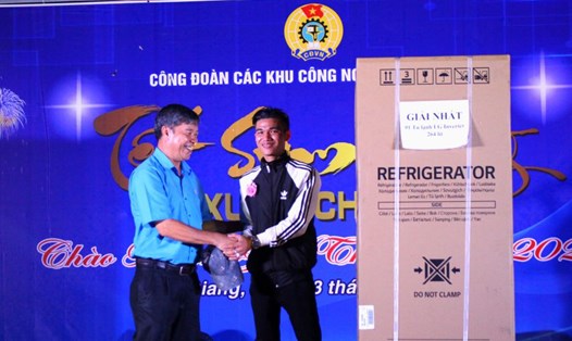 Phó Chủ tịch LĐLĐ tỉnh An Giang Nguyễn Hữu Giang chúc mừng đoàn viên Trần Thanh Quang nhận được tủ lạnh tại sự kiện Tết Sum vầy năm 2024. Ảnh: Lục Tùng