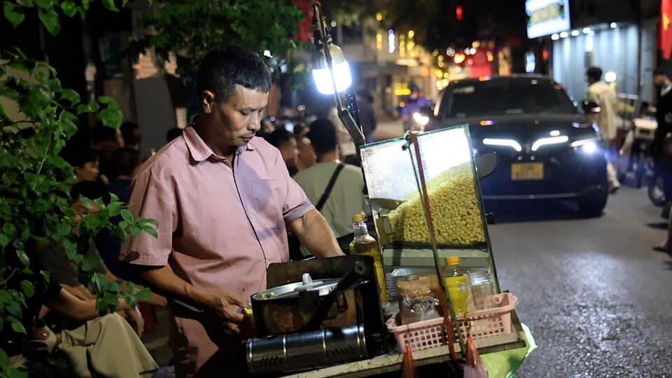 Ong Hoang Van Hanh (My Duc, Ha Noi) dung xe may de ban hang rong tren khu vuc pho co Ha Noi. Ảnh: Viet Anh