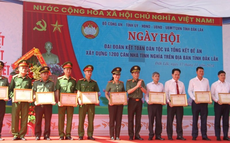 The Minister of Public Security presented Certificates of Merit to individuals with outstanding achievements in implementing the project to build 1,200 houses for the poor in Dak Lak province. Photo: Bao Trung