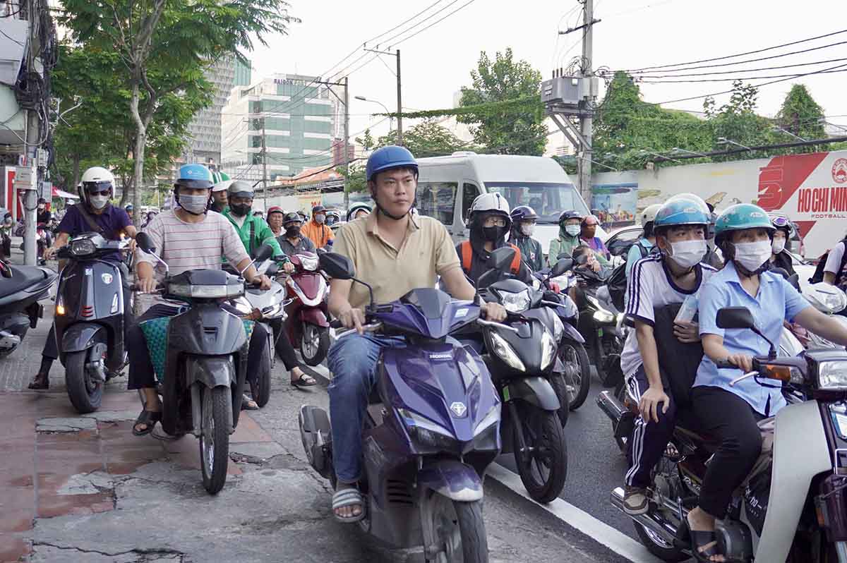 Ho Chi Minh City residents have to drive onto the sidewalk to avoid traffic jams on Nguyen Tat Thanh Street