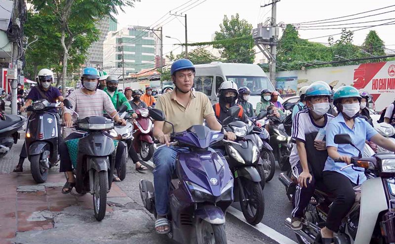 Ho Chi Minh City residents have to drive onto the sidewalk to avoid traffic jams on Nguyen Tat Thanh Street