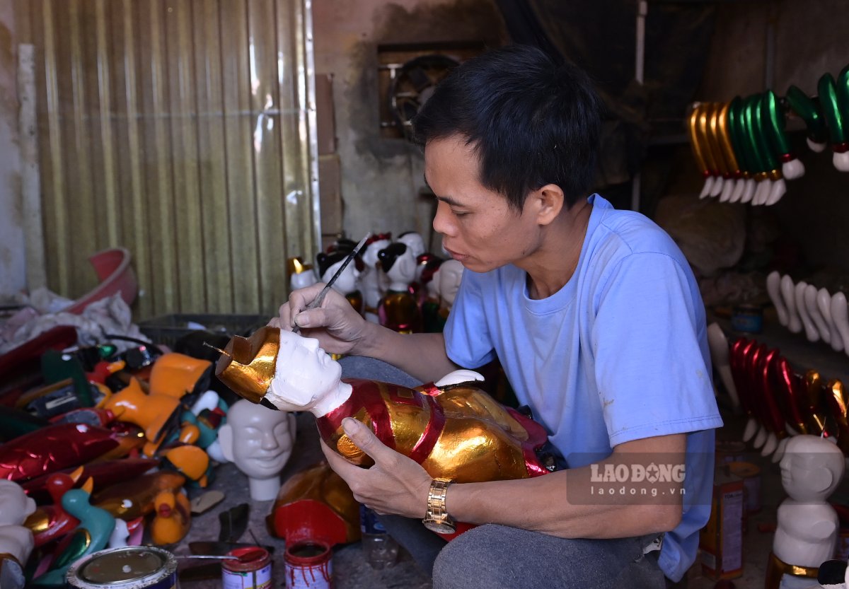 Mr. Phan Van Trien paints to highlight the details of the puppet. Photo: Ha Vi
